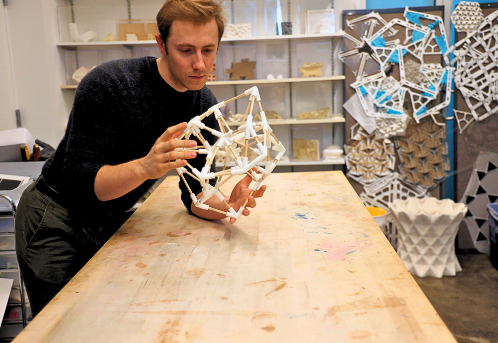 Kobe leaning over a table looking at a model habitat structure