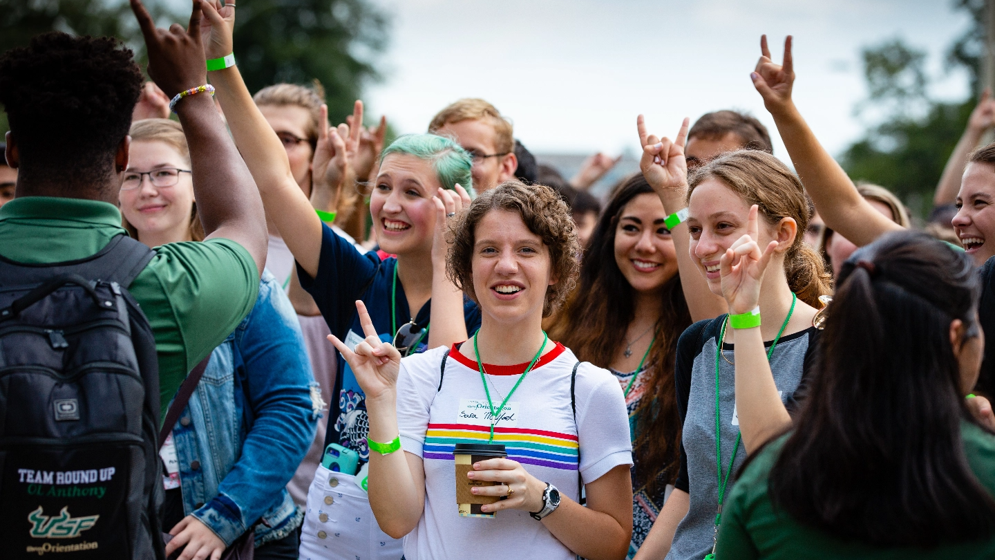 USF Freshmen students attending orientation on campus and holding up the bulls sign.