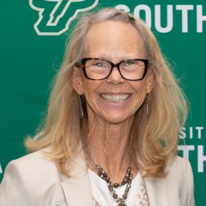 woman in glasses smiling at camera