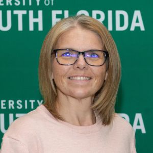 woman in glasses smiling at camera