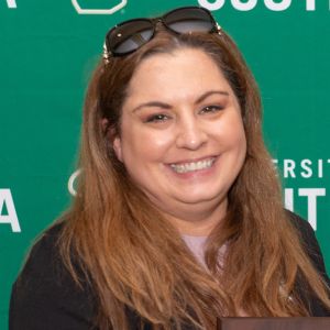 woman smiling at camera with sunglass on her head