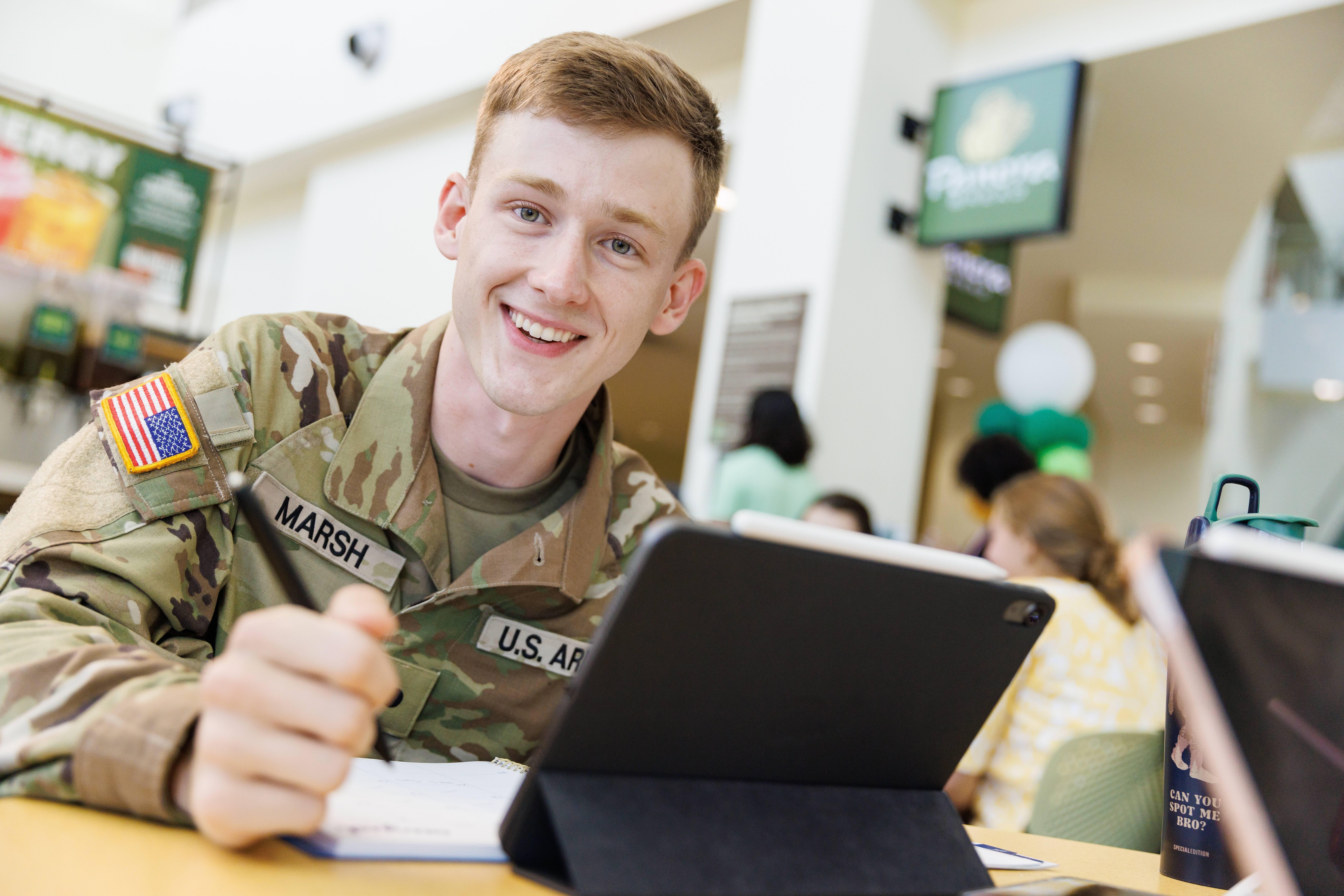 student in fatigues studying