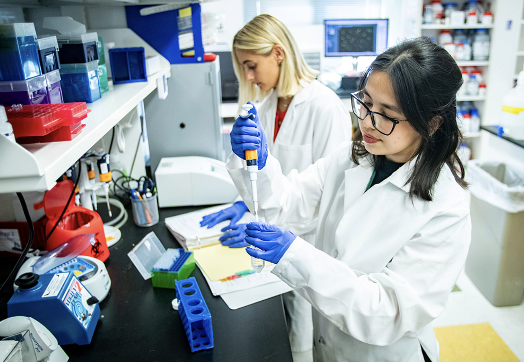 Scientist in white coat using pipette