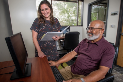 Two people looking at computer screen smiling