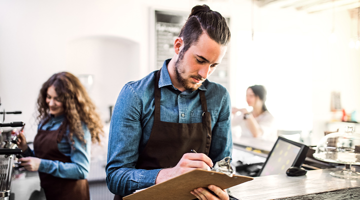 white male college student working behind the counter at an off-campus coffee shop