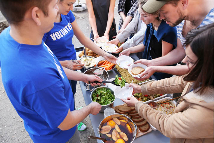 Volunteers preparing and sharing food with others 