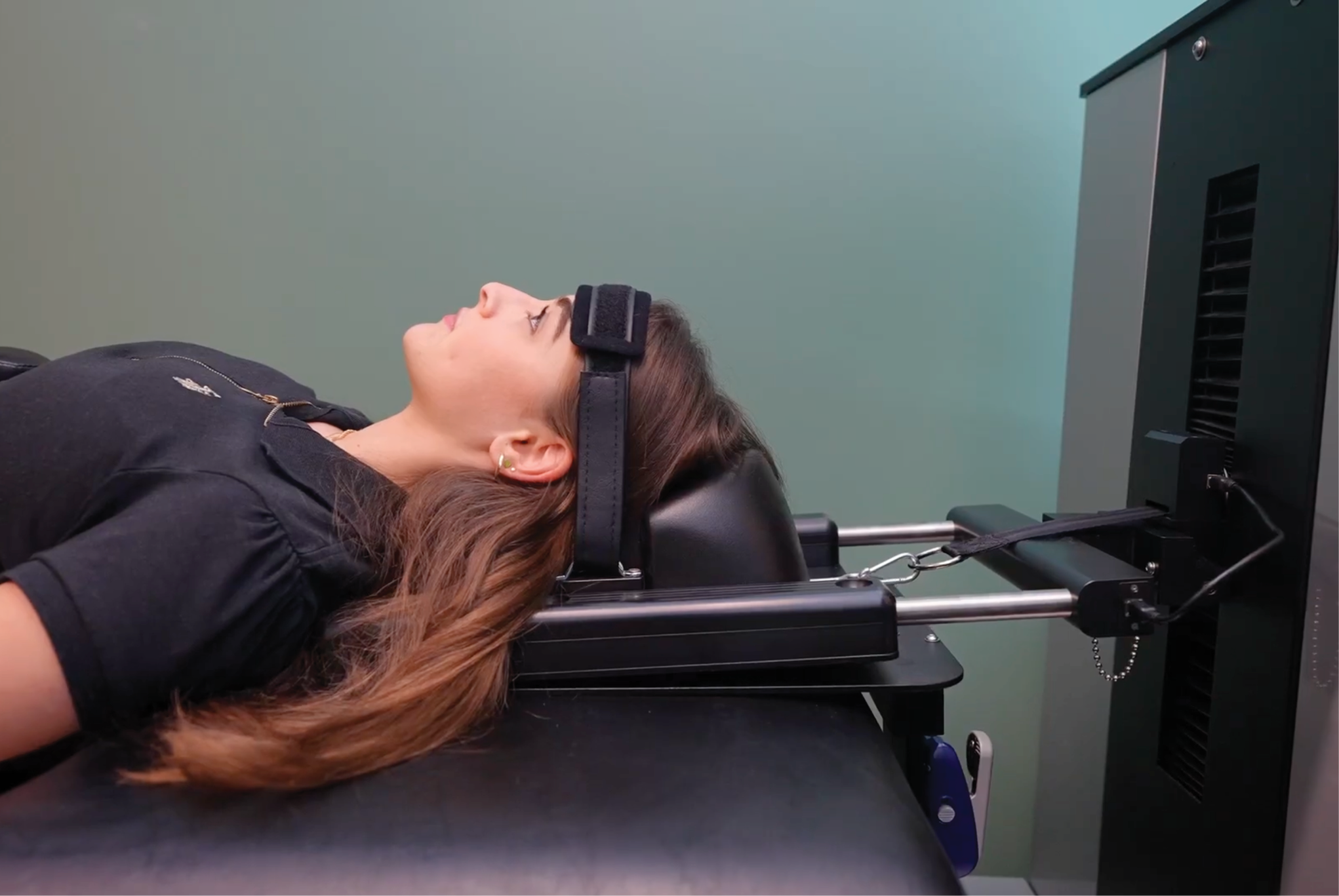 A patient, lying on her back, using the specialized computer‑controlled device DRX9000C