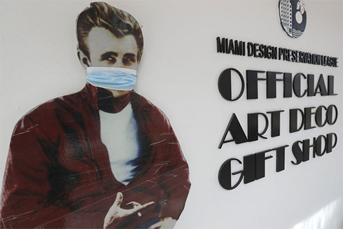 A cutout photo of late actor James Dean wears a mask in front of a gift shop along Miami Beach, Florida's famed South Beach, Tuesday. (AP Photo/Wilfredo Lee) [WILFREDO LEE | AP]