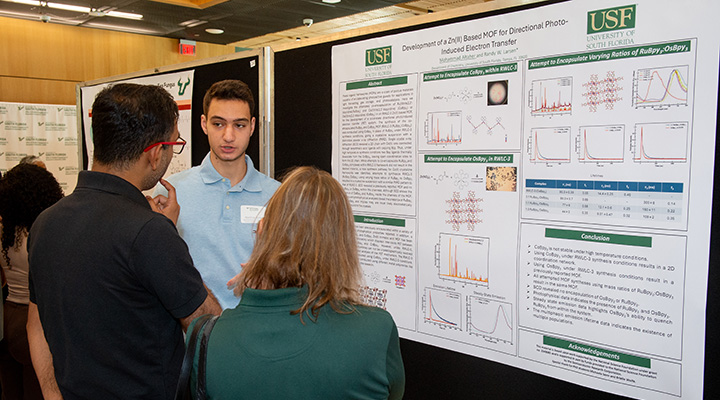 student explains research poster