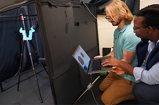 Two faculty members stand with a Bull u light in a studio