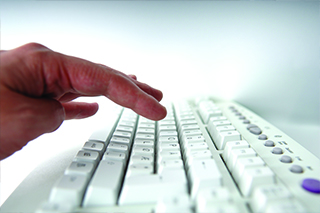 Fingers typing on a computer.