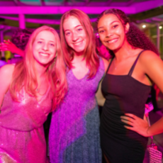 Three students smiling at event