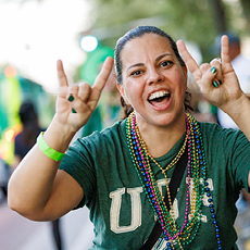 USF fan along with parade route with beads around their neck
