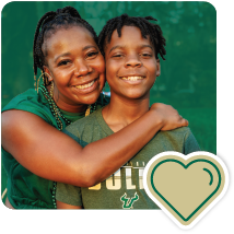 Mom hugging child with a gold heart icon in bottom corner.