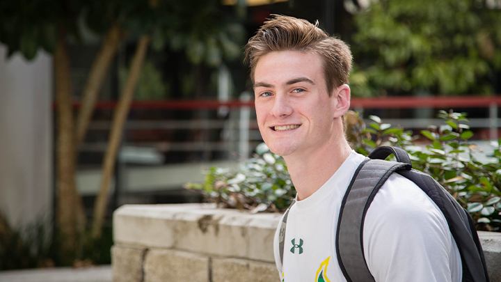 student Dalton sitting outside with backpack