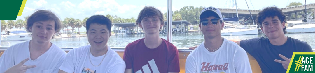 Five boys on a boat smiling