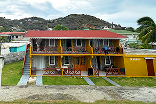 a yellow hotel with red roof
