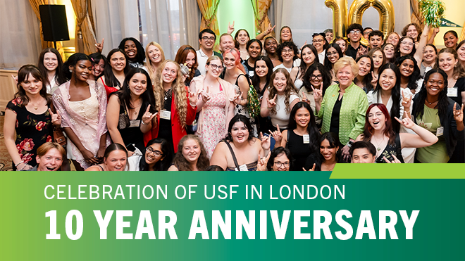 A group of people smiling and holding up "bulls" hands with a lower thirds graphic that says "10 Year Anniversary Celebration of USF In London"