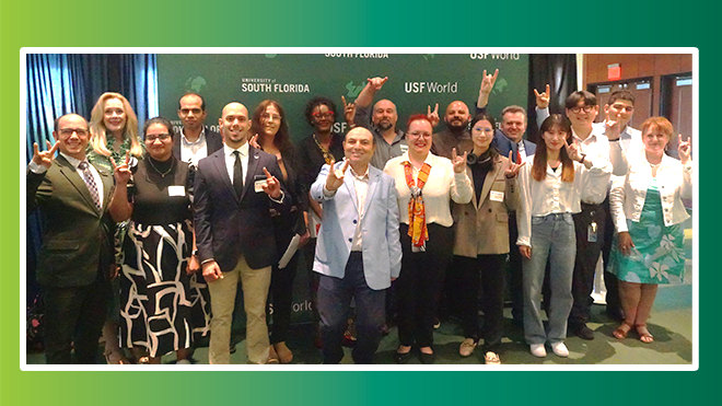 A group of people smiling and holding up "bulls" hands surrounded by a white border and green thicker border