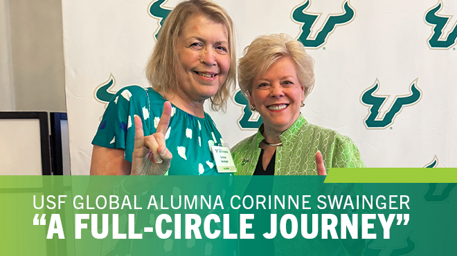 Corinne and USF President Rhea Law standing together smiling raising the bulls