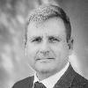 black and white headshot of a male executive in a suit with short sandy-colored hair