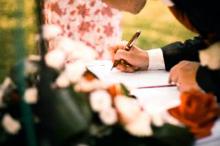 Placeholder photograph of someone signing an agreement in a garden