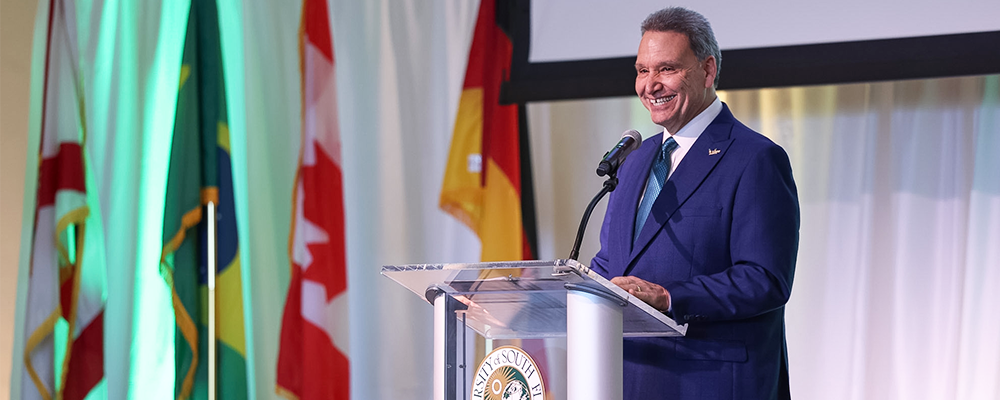 USF President Limayem speaks at a podium to business and university leaders