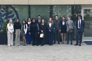 group of USF students dressed in business attire and standing in front of a building in Washington, D.C.