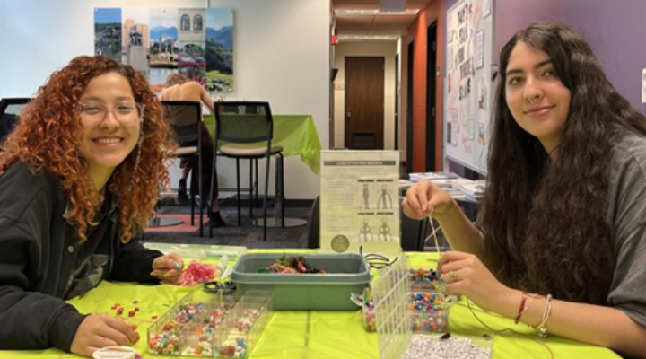 Two female USF international students take a break from classes to make friendship bracelets in the International Student Success Center during "De-Stress Fest"