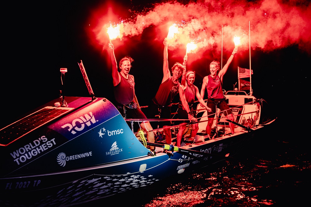 USF team, Salty Science, holding flares in celebration of their successful finish of the World’s Toughest Row-Atlantic race