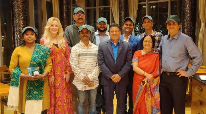 group photo of alumni in Hyderabad, India wearing USF green hats