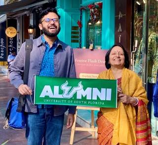 Entrepreneur and USF alumnus Ishan Mitra and Aruna Dasgupta proudly display a USF alumni banner