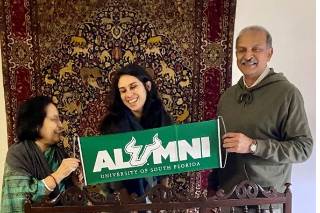 Aruna Dasgupta, Vanessa Martinea, and former Vice President of Ericsson and USF alumnus Rahul Krishna proudly displaying a USF alumni banner