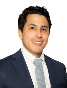 headshot of USF alumnus, Julian Escallon, with dark hair, dark suit jacket, white shirt and grey tie