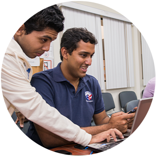 Two people working on one computer