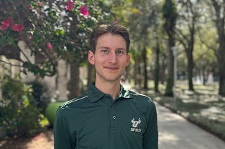 headshot of a young caucasian male posing in a green USF polo shirt