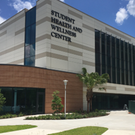 image of the front of the tan brick and white student health services building at the USF Tampa campus
