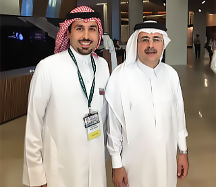 two Arabic men dressed in thwab robes standing in the King Abdulaziz Center for World Culture