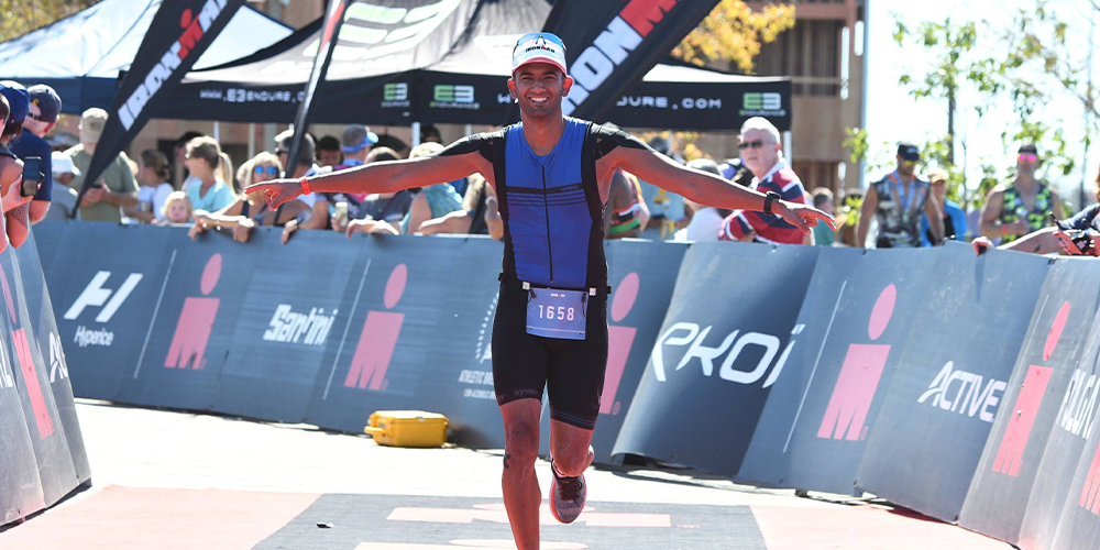 Sharma is running down a stretch of pavement of the Ironman race