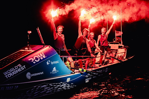 USF team, Salty Science, holding flares in celebration of their successful finish of the World’s Toughest Row-Atlantic race