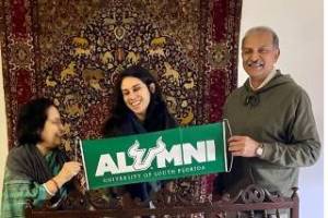 Aruna Dasgupta, Vanessa Martinez, and former Vice President of Ericsson and USF alumnus Rahul Krishna proudly displaying a USF alumni banner
