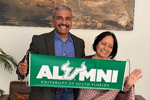 Medical Director and USF alumnus Dr. Sumit Ray and Aruna Dasgupta proudly display a USF alumni banner at Holy Family Hospital in India