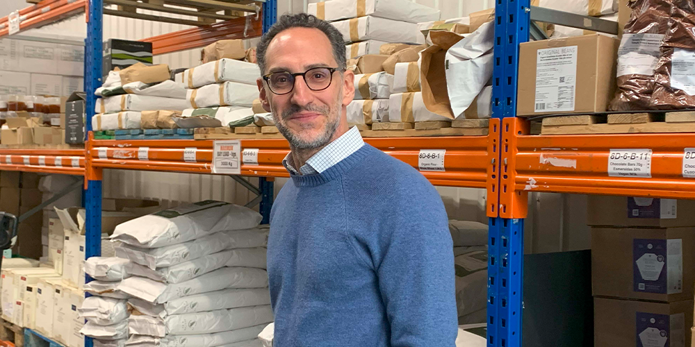 arpesani posing in a warehouse with sacks of ingredients behind him