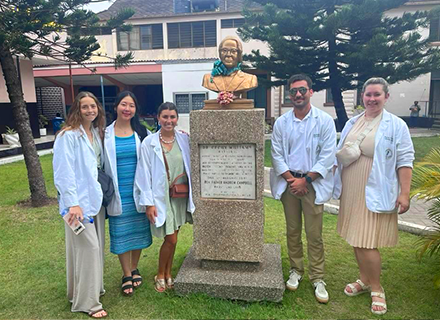 Interns standing by monument