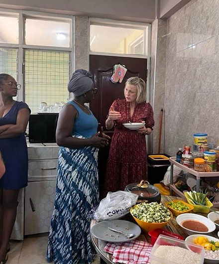 Dr. Wright with Ghana native in a kitchen surrounded by food