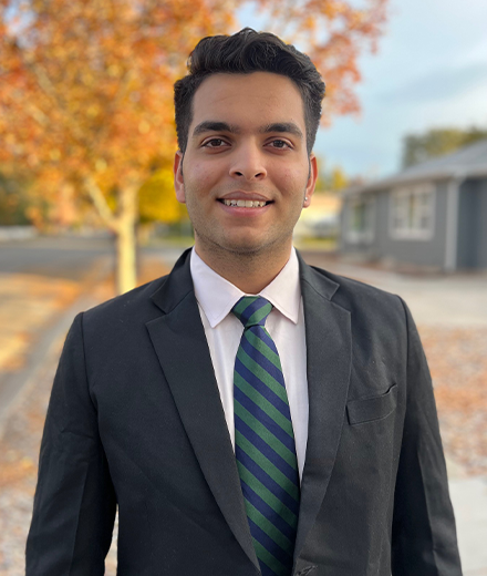 headshot of Mr. Naman Sehgal, USF Students of India Association President; Indian male in a dark suit standing in front of an autumnal maple tree