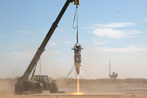 Large crane holding a rocket over a concrete platform