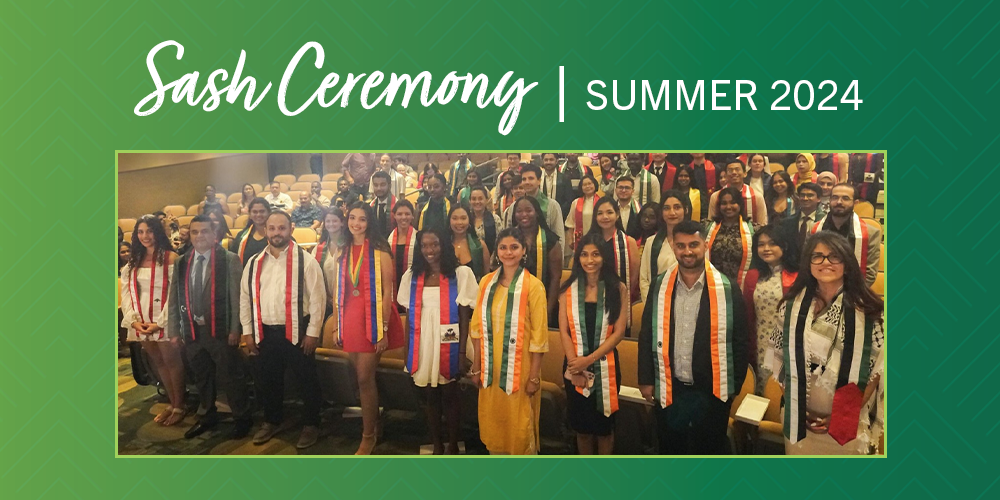 a group of international graduating students with their international sashes on in an auditorium