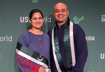 A couple wearing green and white sashes