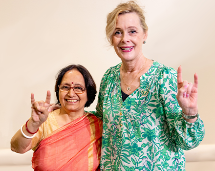 Aruna and Caruson smiling and holding up go bulls hand sign